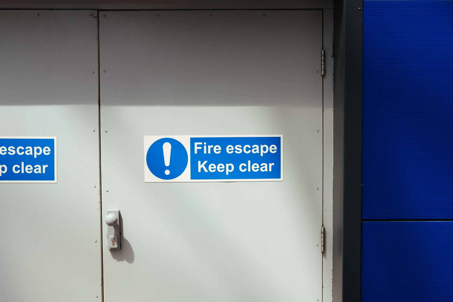 A fire door with a sign 'Fire Escape Keep Clear' for Fire Safety Services