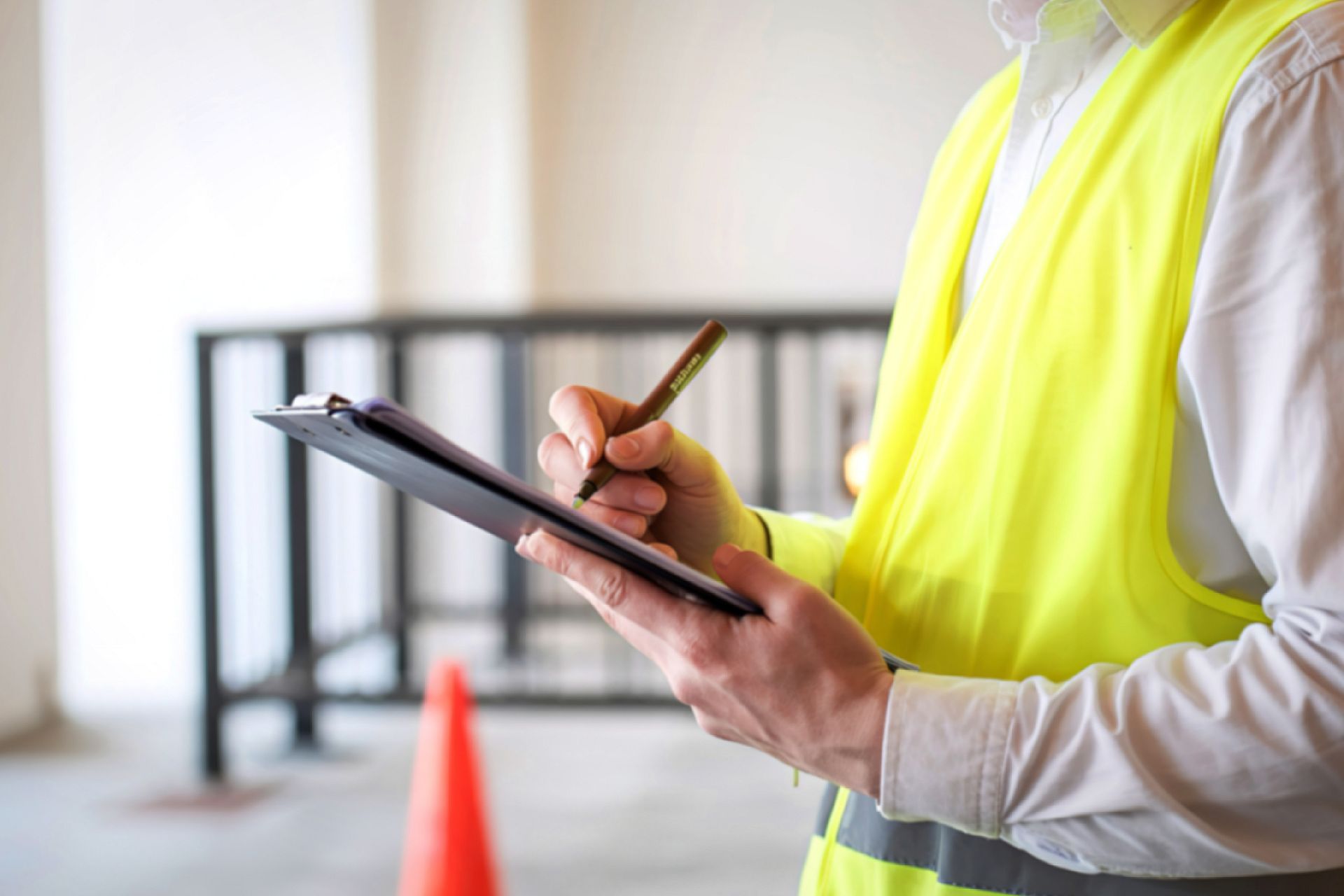Man holding a clip board in high vis showing what does a contract administator do